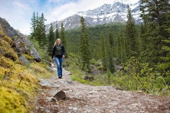A happy woman walking on a path on a mountain hike in Banff National Park