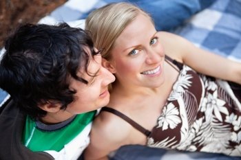 Top view close-up of young man and woman relaxing on picnic blanket