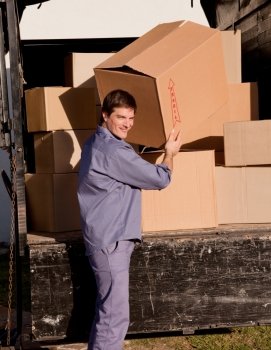 A portrait of a professional mover carrying cardboard boxes