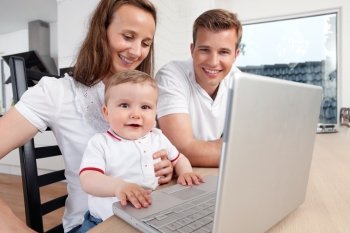 Family of three using a laptop at home