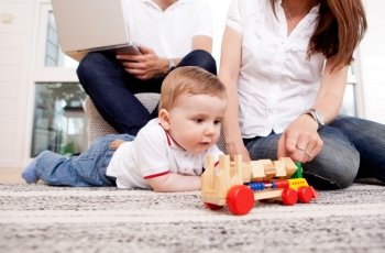 A family together in the living room, son playing on the floor
