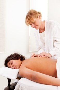 Young male acupuncture patient receiving treatment on back