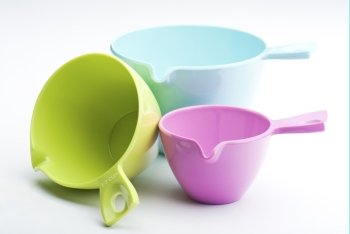 Three Plastic Measuring Cups On A White Background