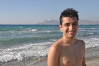 smiling young man at Kos beach in Greece (blue sky)
