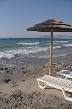 beautiful beach with umbrella and chairs in Kos, Greece (Turkey on the background)