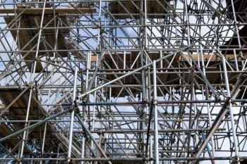 Metal scaffold and woden platforms on construction site 