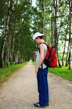 boy with the phone on a path in the woods