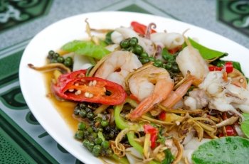 close up  stir fried seafood with mix herbal on white dish