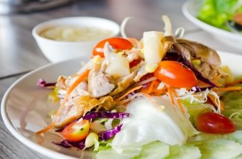 chicken  and fresh vegetable salad  served with creamy sauce in bowl