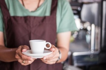 Asian barista serving freshly brewed coffee, stock photo