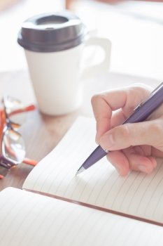 Woman writing a plan on notebook, stock photo