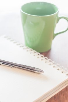 Pen and notebook with green mug, stock photo