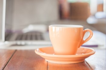 Orange coffee cup on work station, stock photo