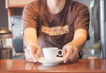 Barista offering mini white cup of coffee, stock photo stock photo