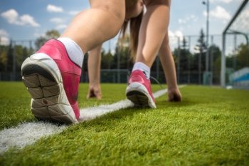 Closeup shot of woman runner feet on start line on grass