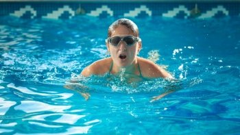 Portrait of young swimmer woman taking a breath at swimming pool