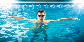 Portrait of young male swimmer taking a breath and relaxing at pool