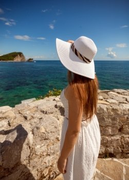 Closeup portrait of beautiful woman in white hat looking at sea