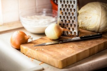 Closeup photo of onion and knife lying on wooden board