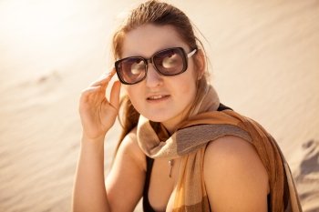 Closeup portrait of brunette woman in sunglasses at sunny day in desert