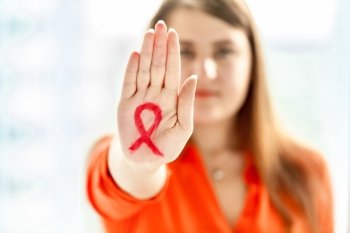 Portrait of young woman showing HIV red loop drawn on hand