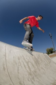 Skateboarder doing a BS feeble grind on a curb.