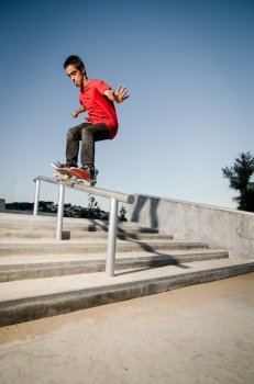 Skateboarder doing a 50-50 grind on rail.