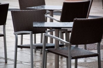 Chairs and tables  in the outdoor section of a cafe deserted of customers on a dull rainy day in Stuttgart, Germay