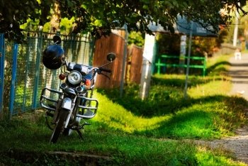 motorbike near fence in village