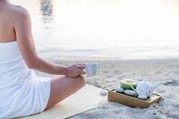Yoga woman meditating at serene beach sunset