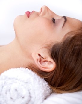 Close up shot of Sleeping young woman in the spa over white background