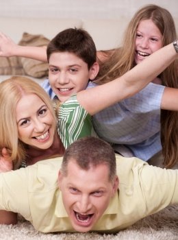 Happy family Lying On Top Of Each Other In living room