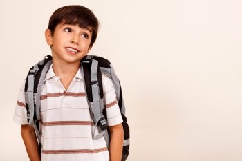 Portrait of young schoolboy with back pack looking left cornor, isolated on ivory background