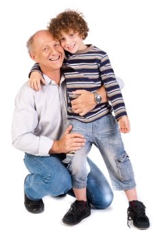 Grandfather embracing his grandson, indoors against white background..