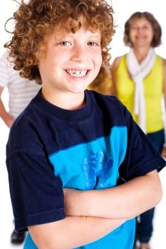 Young cute boy in focus with family in the background, isolated over white.