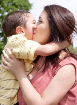 Children kissing his mom in a park,outdoor