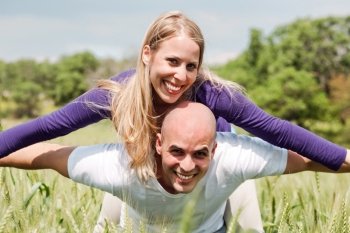 Young man giving shoulder ride to her girlfriend in outdoors