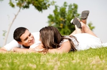 happy young Couple lie down on grass look each other