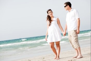 full length image of Young couple holding hands and walking on the beach