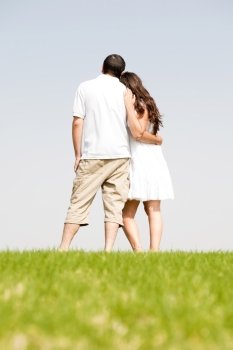 Rear view of romantic young couple standing on the park
