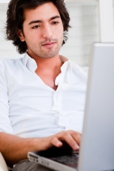 attractive  young man browsing the internet at home