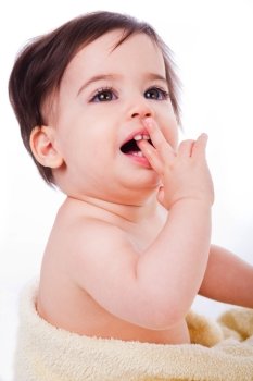 Baby with finger in mouth looking up in isolated background