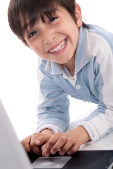 Portrait of cute caucasian boy smiling with laptop over white background