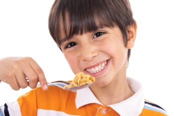 Smiling young boy with spoon of flakes, closeup on isolated white background