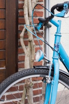 Light Blue Bicycle lent against Brick Wall