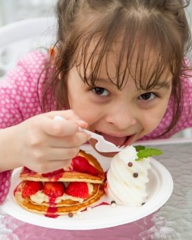 Pretty Asian Girl Eating a Strwaberry Waffle with ice cream
