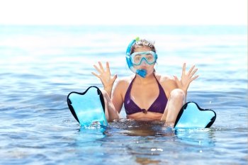 Beautiful tanned girl with snorkeling equipment having fun in shallow water