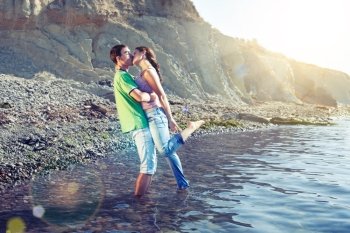 Lovers kissing passionately while standing ankle-deep in water