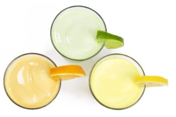 three cold citrus fruit milkshakes from top. three cold citrus fruit milkshakes from top on white background