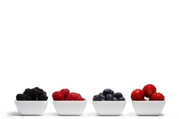 row of wild berries in bowls. row of wild berries in bowls on white background